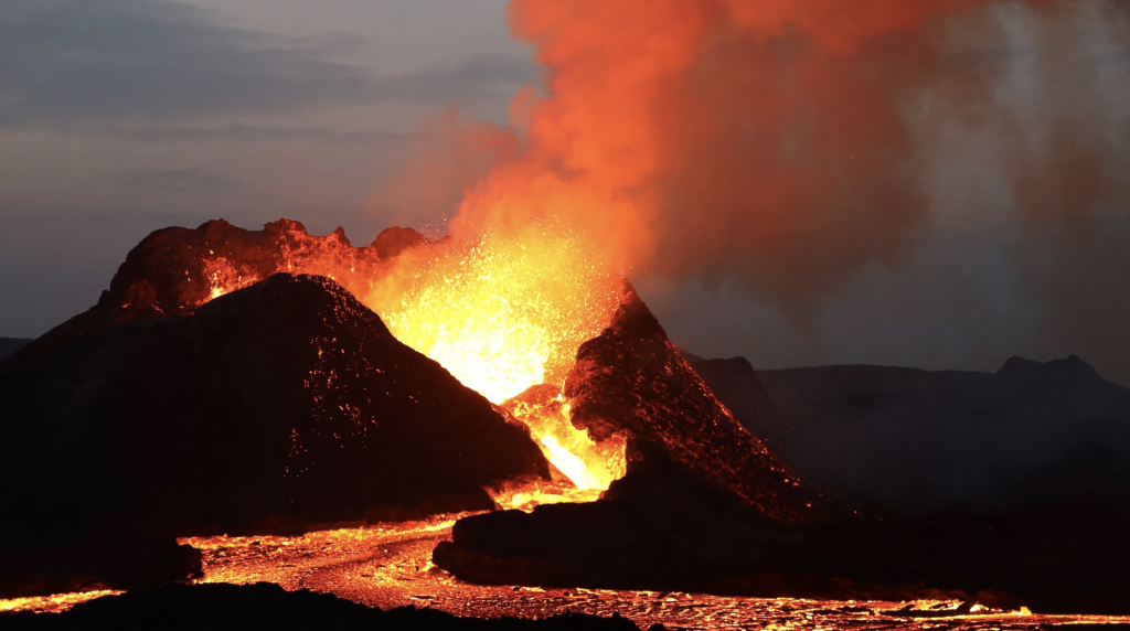 An exploding volcano in Iceland with hot lava pouring out 